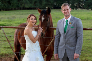 Bride and groom posing with a horse