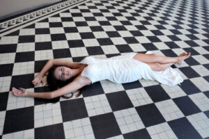 brunette model in white dress on checkerboard floor