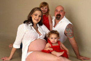 pregnant mom posing with family members for maternity photography session